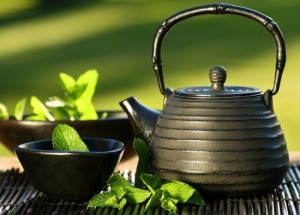 Black iron asian teapot with sprigs of mint for tea