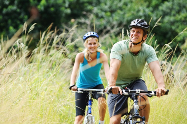 Happy couple riding bicycles outside, healthy lifestyle fun concept